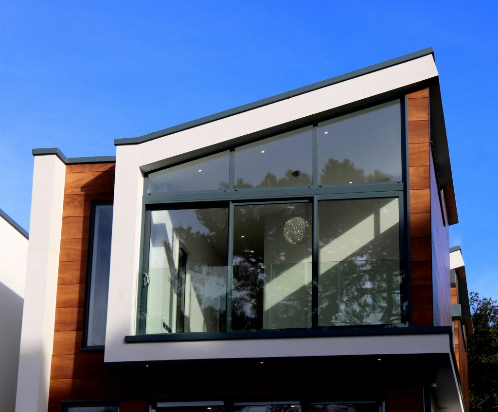 Modern huis met glazen ramen en houten gevel.